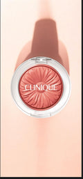 Rubor en polvo Mi tienda CLINIQUE Cheek Pop en tono coral con diseño de margarita en relieve sobre fondo rosado